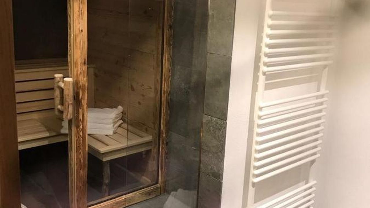 Badezimmer mit alpenländischer Design-Sauna und ebenerdiger Wellnessdusche Badezimmer mit alpenländischer Design-Sauna und ebenerdiger Wellnessdusche